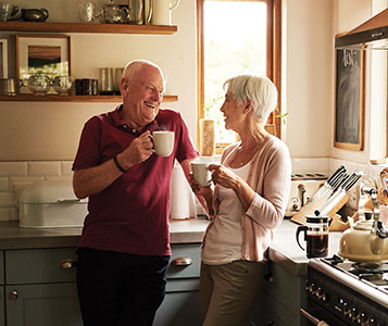 Older couple standing in their kitchen. Links to Gifts of Life Insurance
